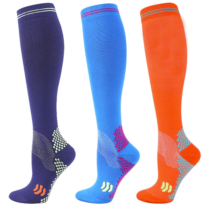 Three pairs of medical grade compression socks in navy blue, royal blue, and orange.