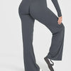 A close-up shot of a model wearing dark gray high-waist yoga pants.