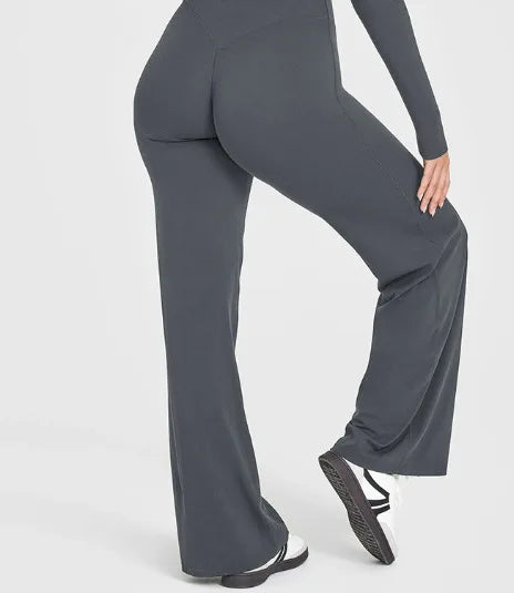 A close-up shot of a model wearing dark gray high-waist yoga pants.