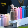 A row of pink and purple stainless steel vacuum flask water bottles with straws displayed on a white wooden surface.