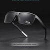 A pair of black rectangular polarized sunglasses with a dark frame and polarized lens resting on a dark surface.