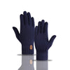 A pair of navy blue knitted winter gloves displayed on a reflective surface.