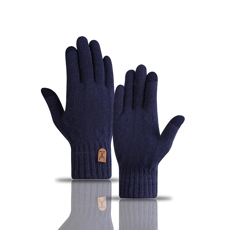 A pair of navy blue knitted winter gloves displayed on a reflective surface.