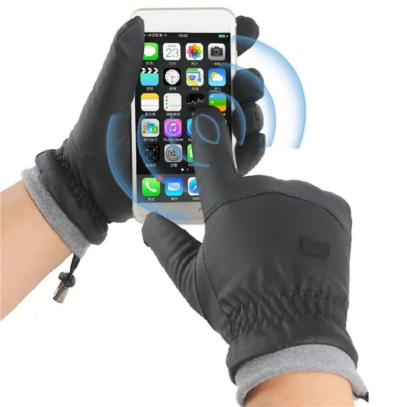 A hand wearing black ski gloves is using a smartphone, with blue light emanating from the screen.