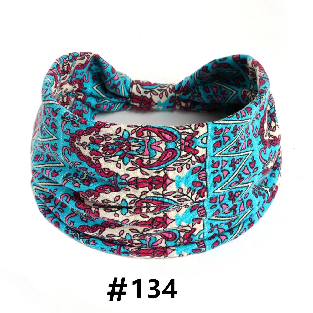 A close-up of a colorful boho print cotton headband featuring pink, teal, and cream patterns.