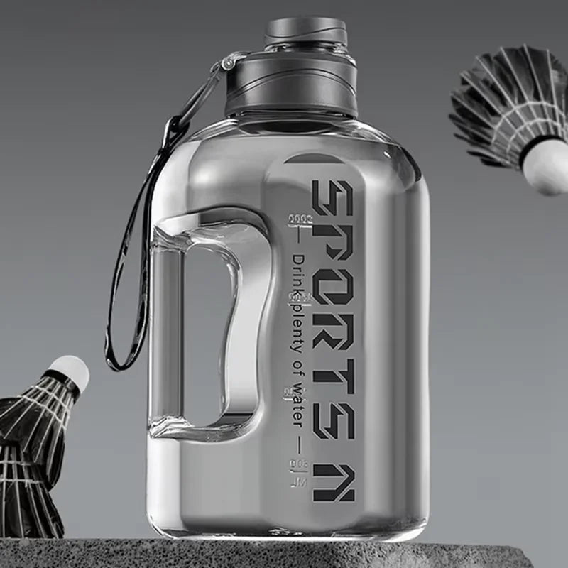 Klare, große wiederverwendbare Sportflasche mit Metallverschluss und Leine, auf grauer Oberfläche.