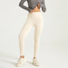 A model wearing beige seamless high-waist yoga leggings and a gray top, standing and posing.