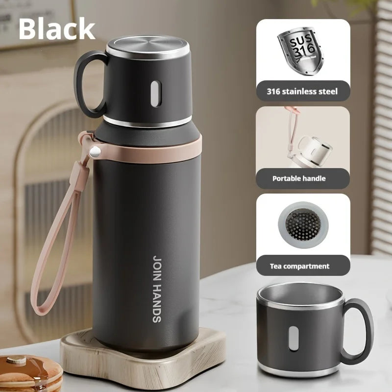 A black 316 stainless steel insulated water bottle with a portable handle and tea compartment is shown next to a matching mug