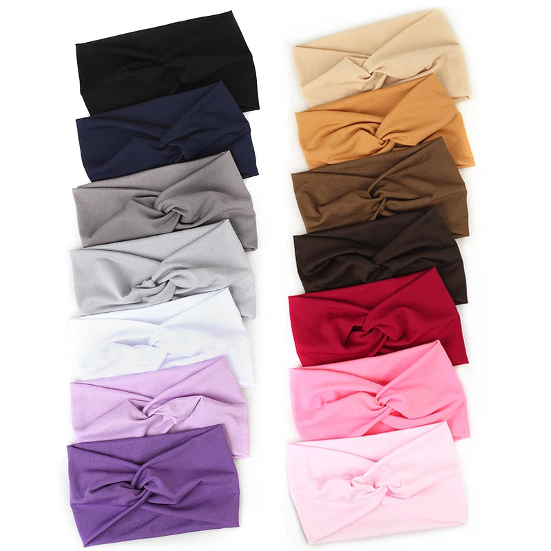 A collection of twisted criss cross elastic headbands in various shades including black navy gray beige brown and pink purple
