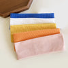 A stack of five elastic hairbands in blue, white, yellow, orange, and pink for fitness and yoga.