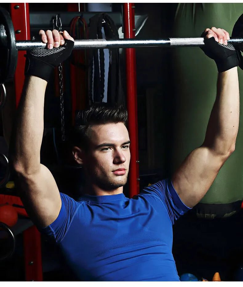 A muscular man lifts a barbell with fitness workout gloves in a gym setting.