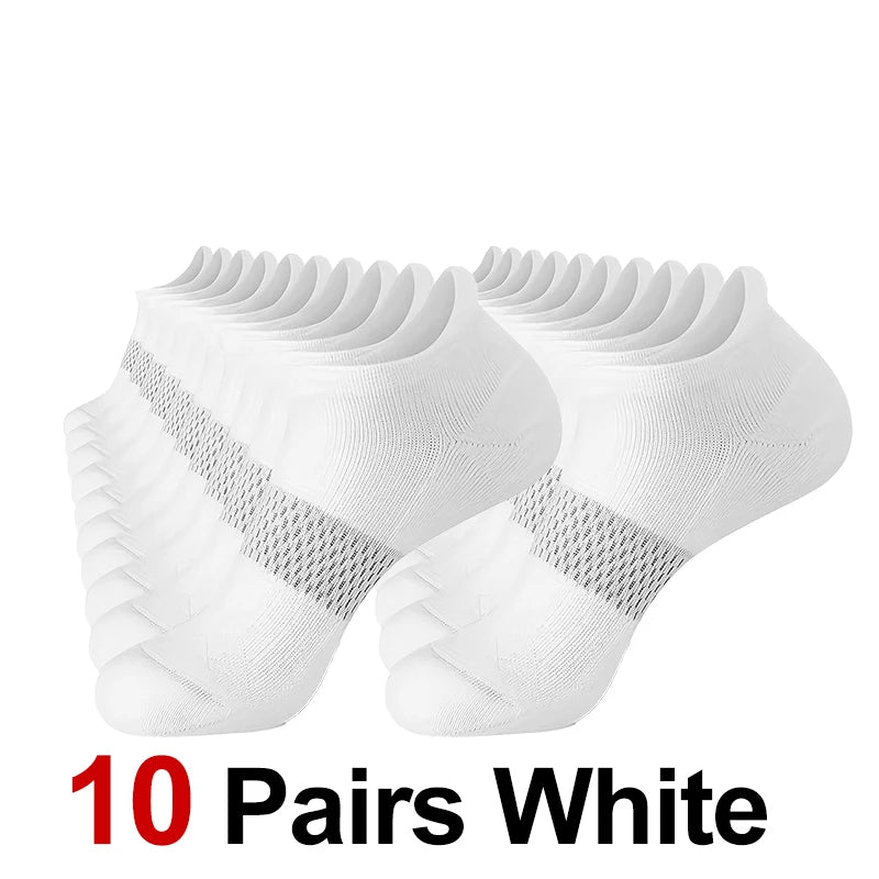 Ten pairs of white performance compression ankle socks laid out.