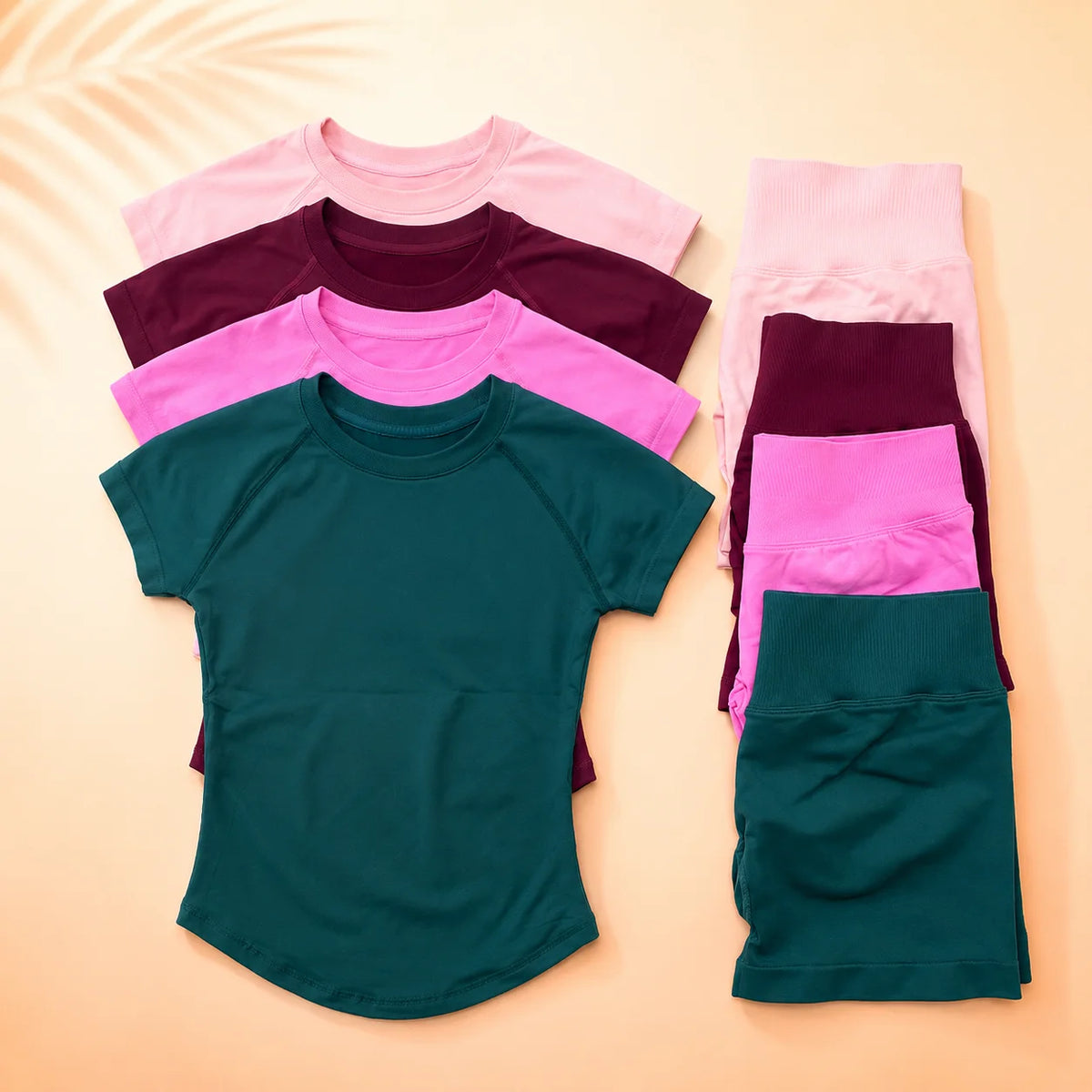 A set of seamless high-waist yoga tops and bottoms in various shades of pink, purple, and teal laid out on a light background