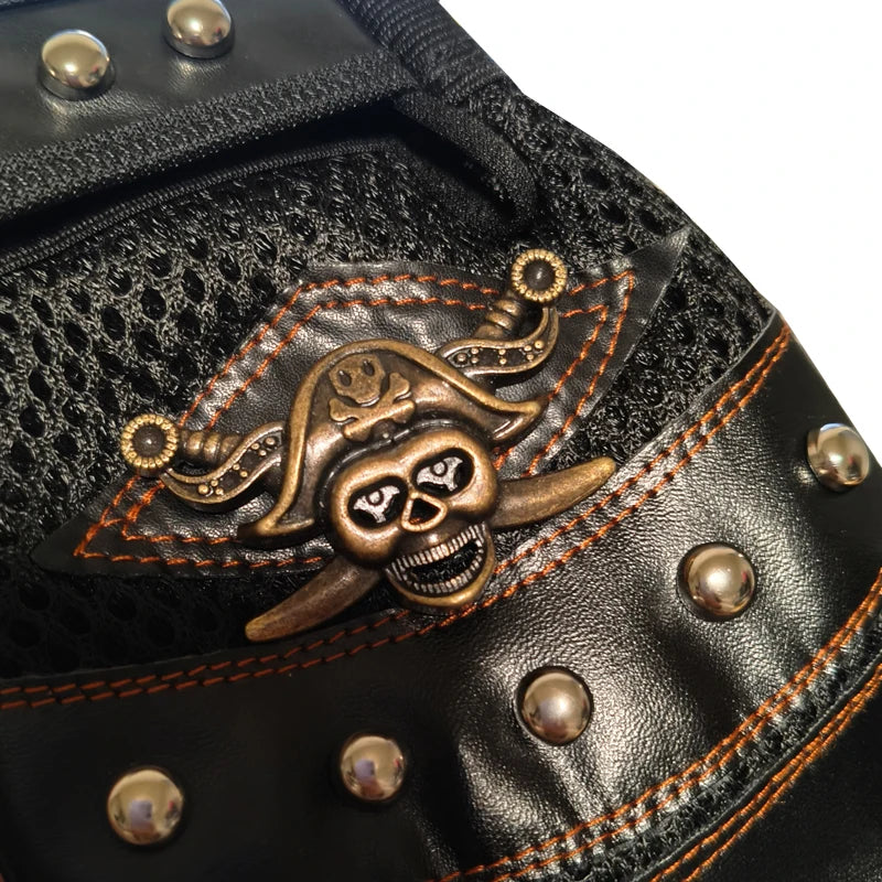 Close-up of black leather motorcycle riding gloves featuring a brass pirate skull emblem.