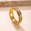 A gold-toned statement ring featuring a band set with clear cubic zirconia stones.