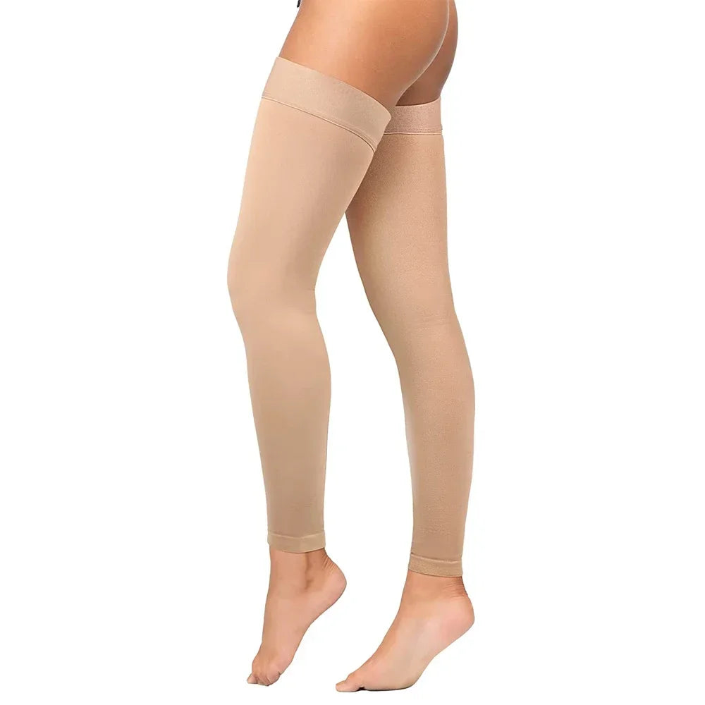 Una persona lleva mangas de compresión terapéuticas beige en sus piernas.
