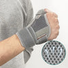 A hand wearing a gray flexible thumb splint wrist brace for joint support.