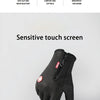 A black glove with a sensitive touch screen is shown resting on a smartphone.