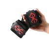 Une main tient un bandage de poignet noir avec un motif de nœud celtique rouge.