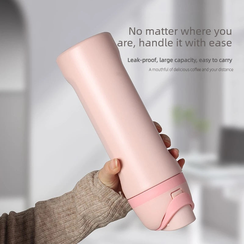 A hand holds a pink insulated stainless steel water bottle with a dual drinking spout.