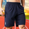 Navy blue men's quick dry jogging shorts worn by a person outdoors.