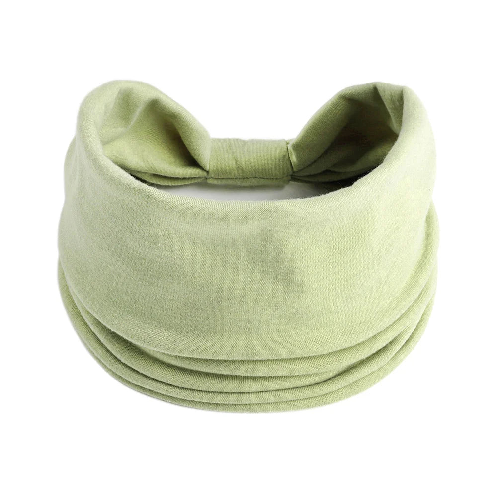 Foulard en coton bohème vert olive, noué en nœud, montré à plat.