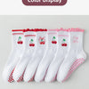 Une rangée de chaussettes de yoga blanches avec broderies rouges et roses et antidérapantes, présentées sur un fond clair.