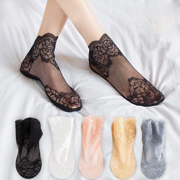 A collection of black, white, pink, yellow, and gray lace mesh ankle socks displayed on a white sheet.