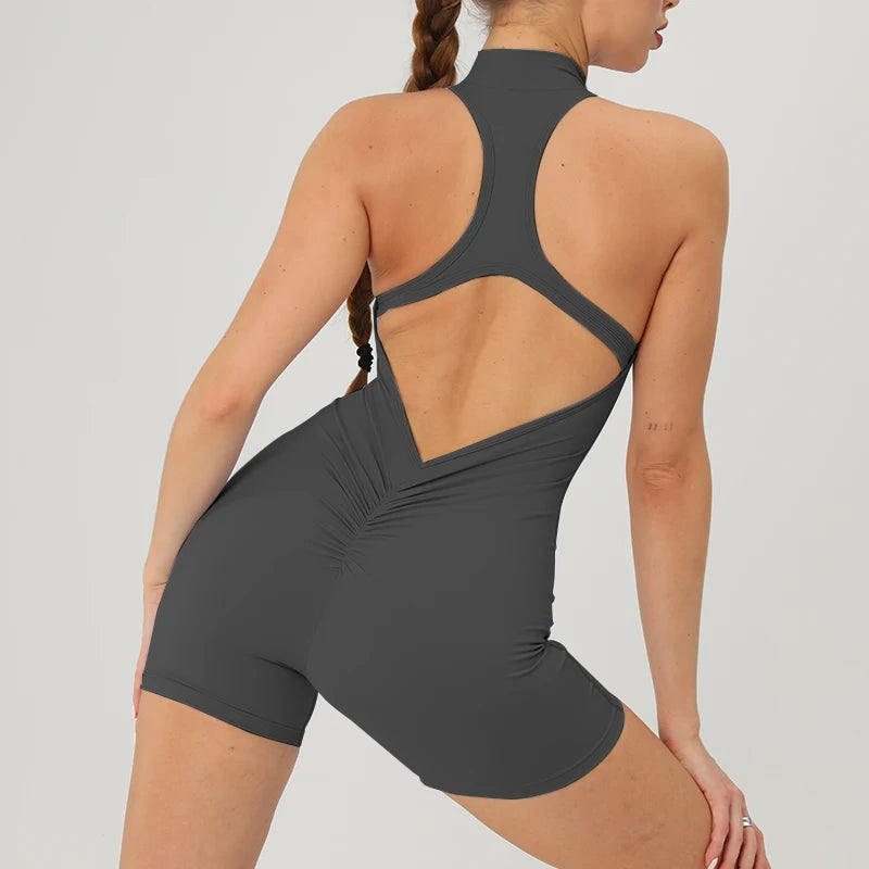A woman wearing a gray backless fitness jumpsuit, shown from the back and side.