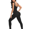 A woman models a black ribbed nylon bodycon jumpsuit, showing the front and side view.