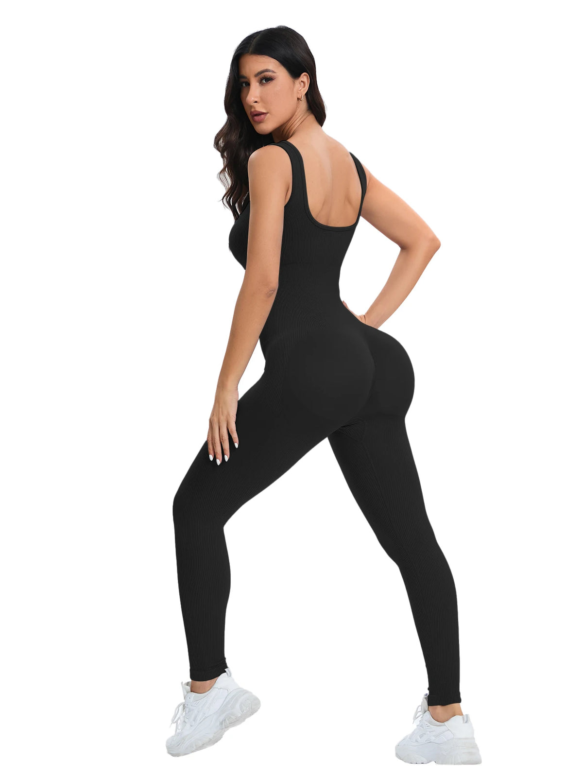 A woman models a black ribbed nylon bodycon jumpsuit, showing the front and side view.