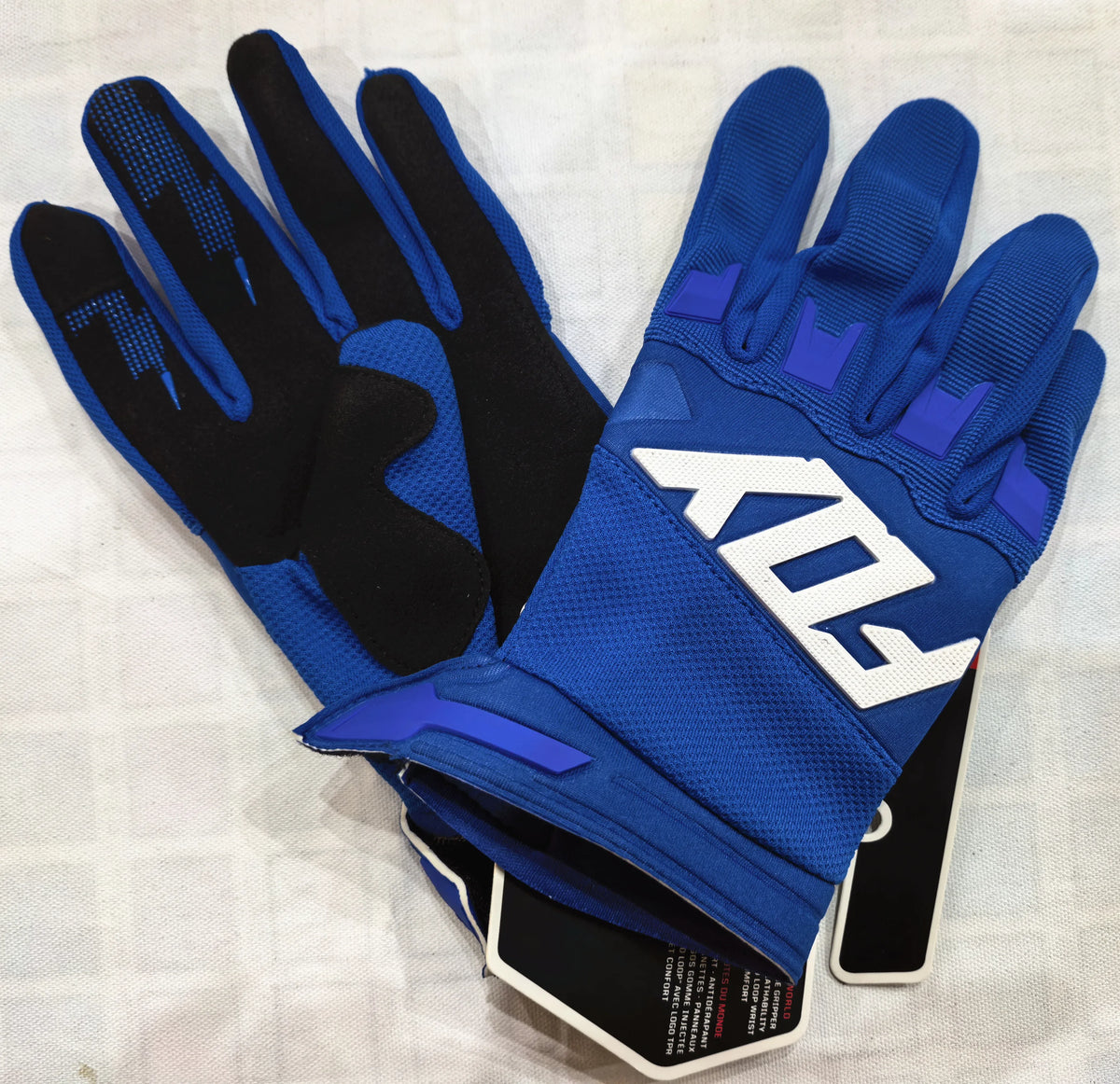 A pair of blue and black durable motorcycle off-road riding gloves are displayed on a white surface.