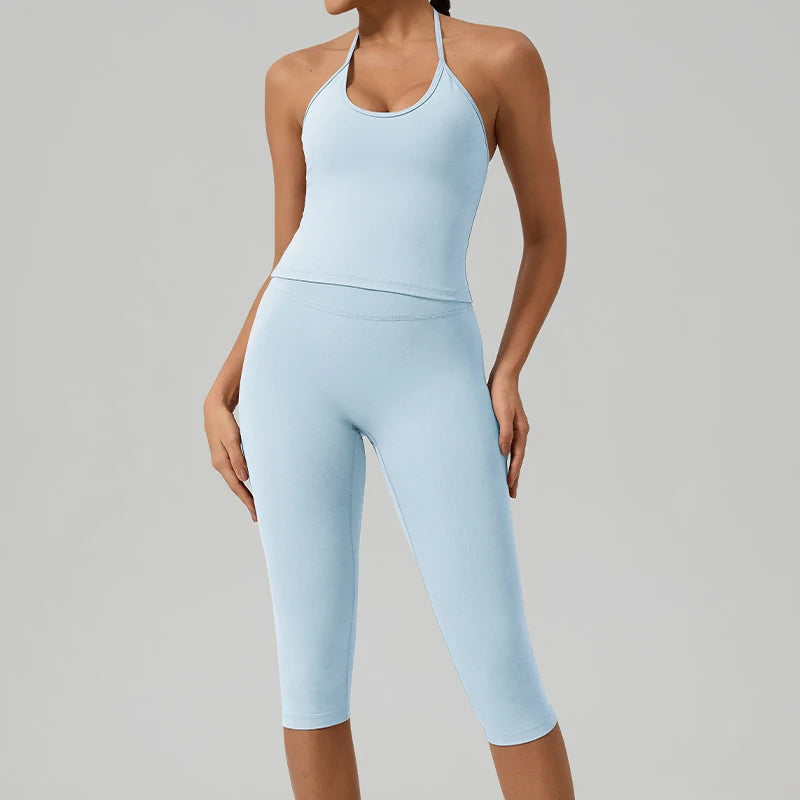 Eine Frau trägt ein hellblaues zweiteiliges Yoga-Activewear-Set aus Tanktop und Leggings.