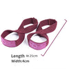A pair of maroon gym wrist wraps with pink accents shown flat.