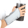A hand is holding a silver insulated cup while wearing a gray ergonomic wrist support brace.