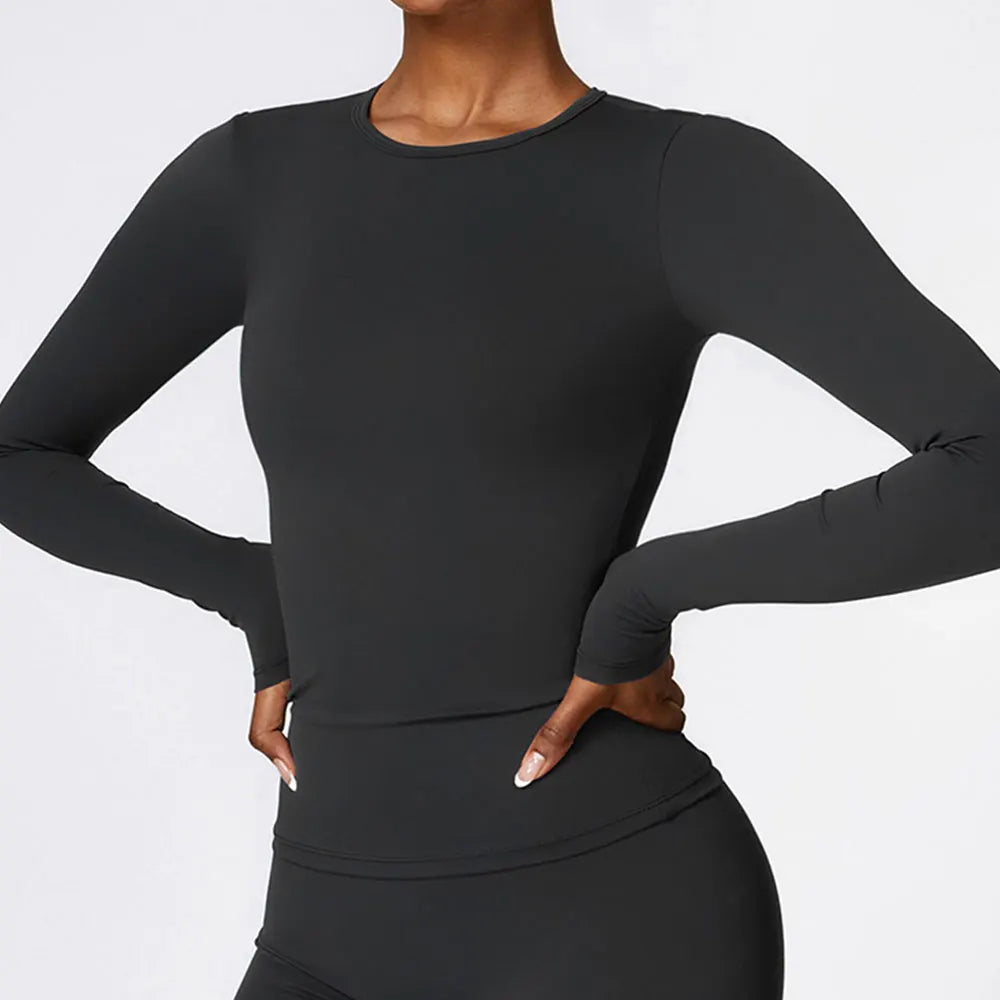 A woman wearing a long-sleeved black yoga and fitness t-shirt.