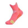 A bright pink running sock featuring white stripes and orange dots with neon green accents.