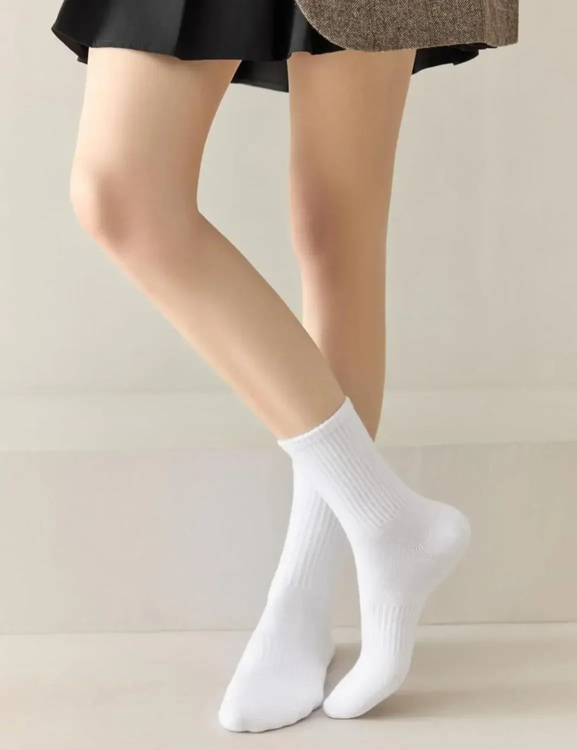 Gros plan sur les jambes et les pieds d'une personne portant des chaussettes en laine blanches tricotées.