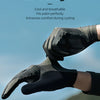 Close-up of black elastic fabric cycling gloves being worn outdoors against a blurred green landscape.