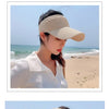 A woman wearing a beige breathable anti-UV adjustable sun hat outdoors on a beach.