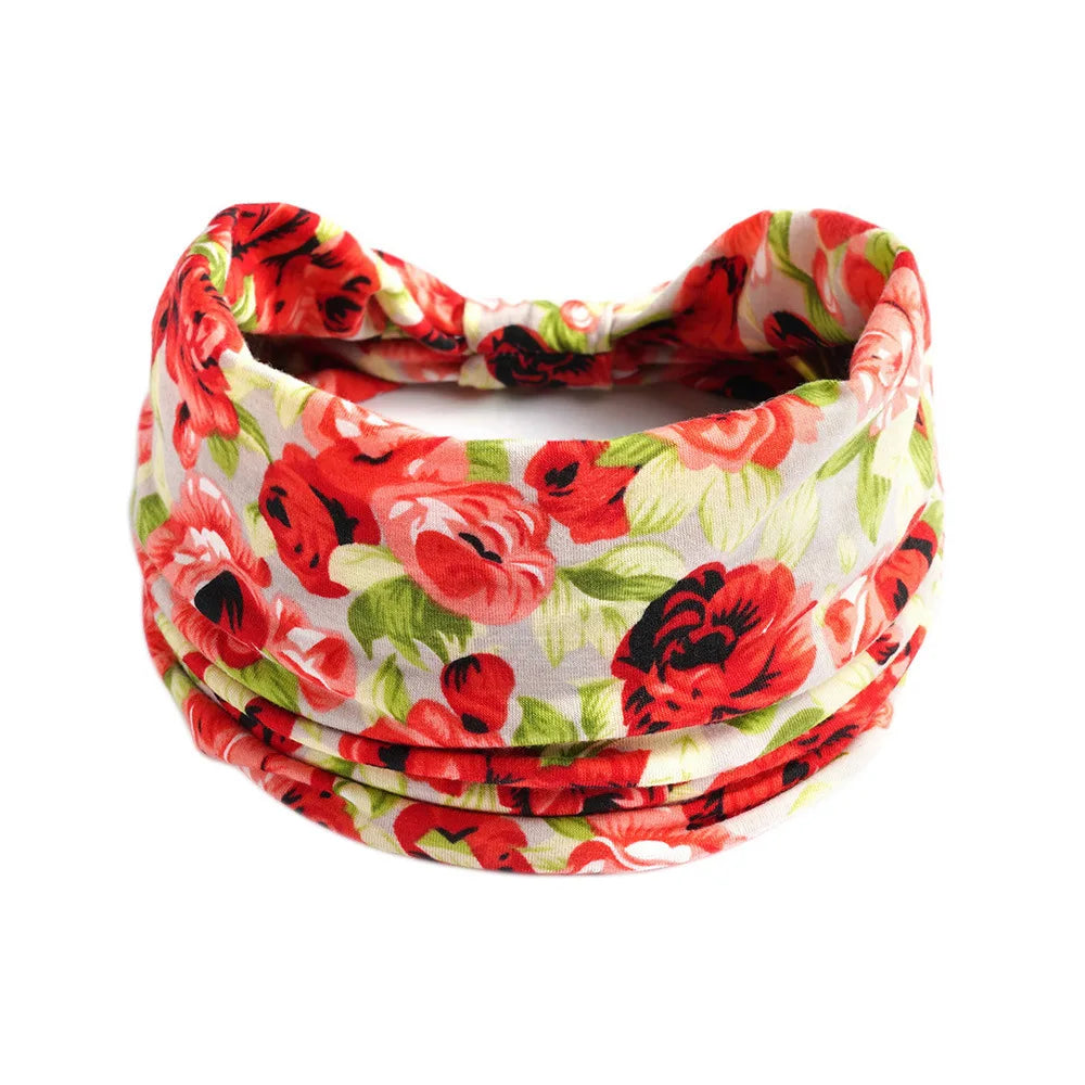 A stack of red and green floral patterned cotton stretch headbands.