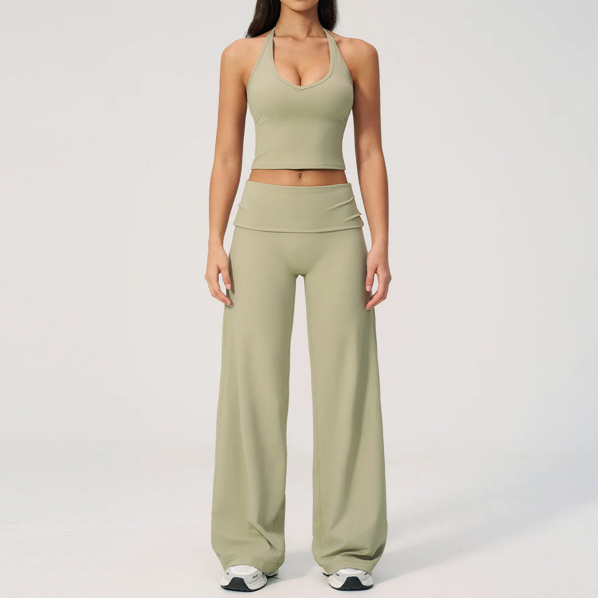 A woman wearing a light olive green women's premium fitness tracksuit top and matching pants.