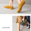 A person wearing mustard yellow cotton crew socks with tan trousers.