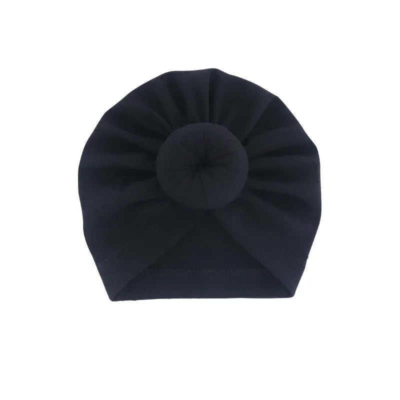 Dunkelblaue Baumwollbaby-Turban-Haube, gefaltet in runde Form.