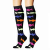 A pair of black compression elastic socks featuring colorful fish patterns in pink, yellow, green, and blue.