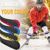 Un joueur de hockey portant un casque et un maillot rouge tient une crosse avec diverses gaines de protection colorées.