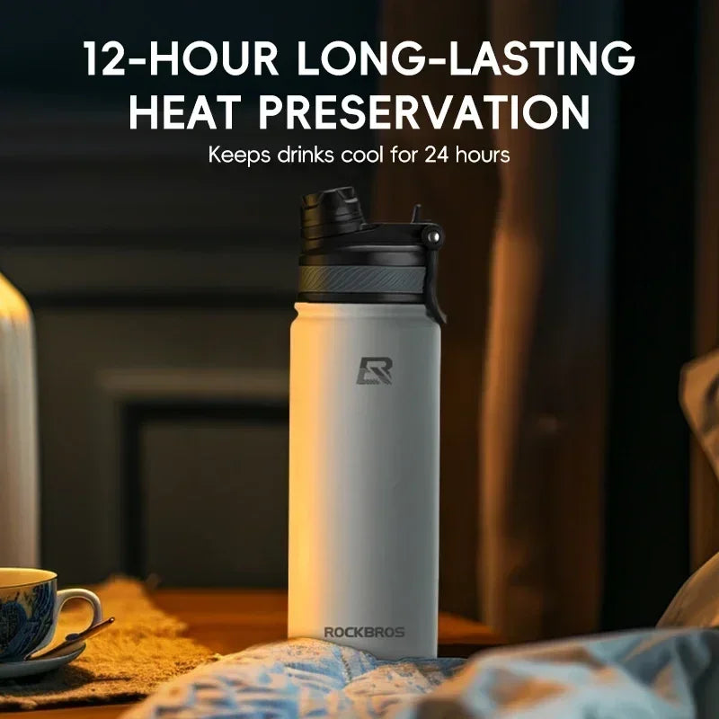 A white insulated stainless steel thermal water bottle is shown standing on a wooden surface.