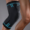 A black compression knee support sleeve worn on a person's leg.