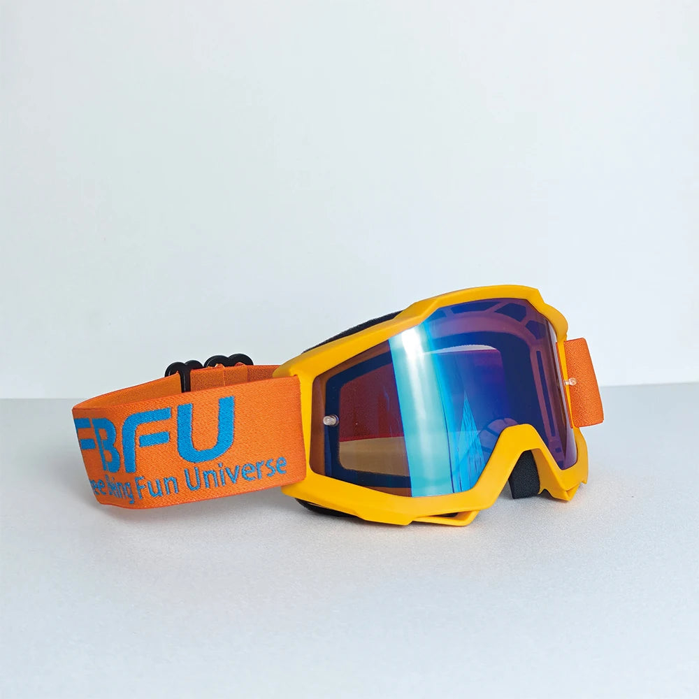Orange and black sport-grade skiing goggles with blue mirrored lenses resting on a light surface.