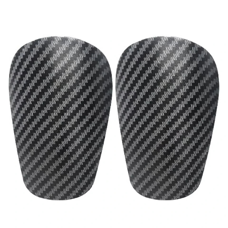 Un par de espinilleras de fútbol mini con patrón negro y gris.
